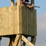 Deelnemers schieten een geweer op de top van een piraterij op de Forest Games