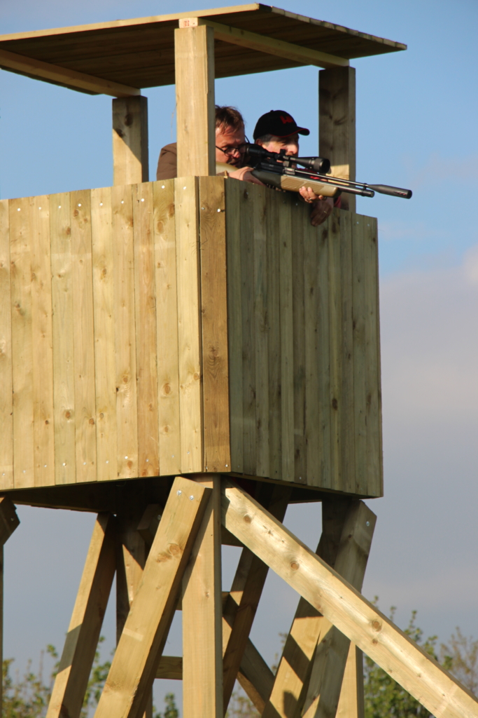 Deelnemers schieten een geweer op de top van een piraterij op de Forest Games