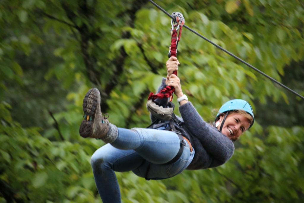 participant on a zip line descent during an aerial course