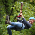 participant on a zip line descent during an aerial course