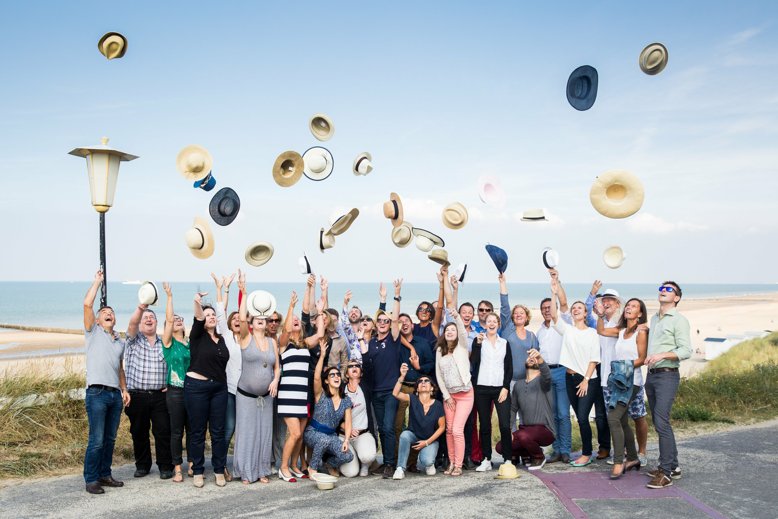 Gelukkige deelnemers gooien hun hoed in de lucht op de zeedijk tijdens de Roadmap Trophy