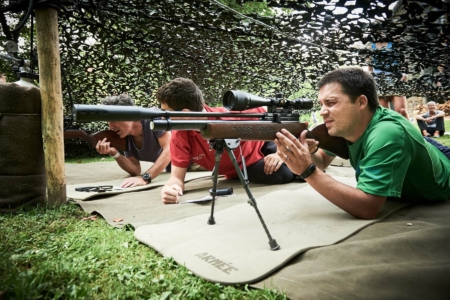 participants sous un treillis tirant au fusil lors d’un Adventure Trail