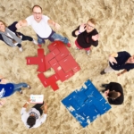 puzzle: aerial view of participants doing puzzles during the Beach Olympics