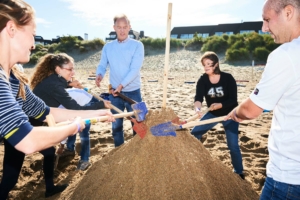 participants réalisant avec du sable une épreuve d'un team building à la mer du nord