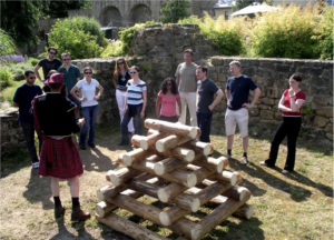 équipe face à une pyramide de rondins de bois lors de Highland Games
