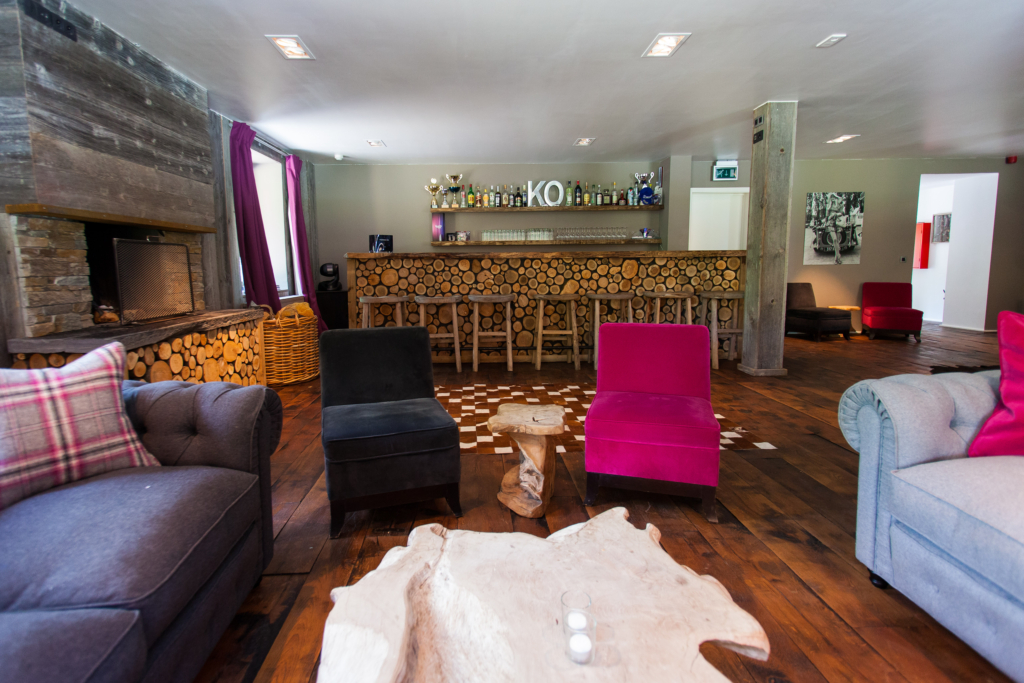 Le salon avec le bar et la cheminée intérieure du tero lodge jalhay