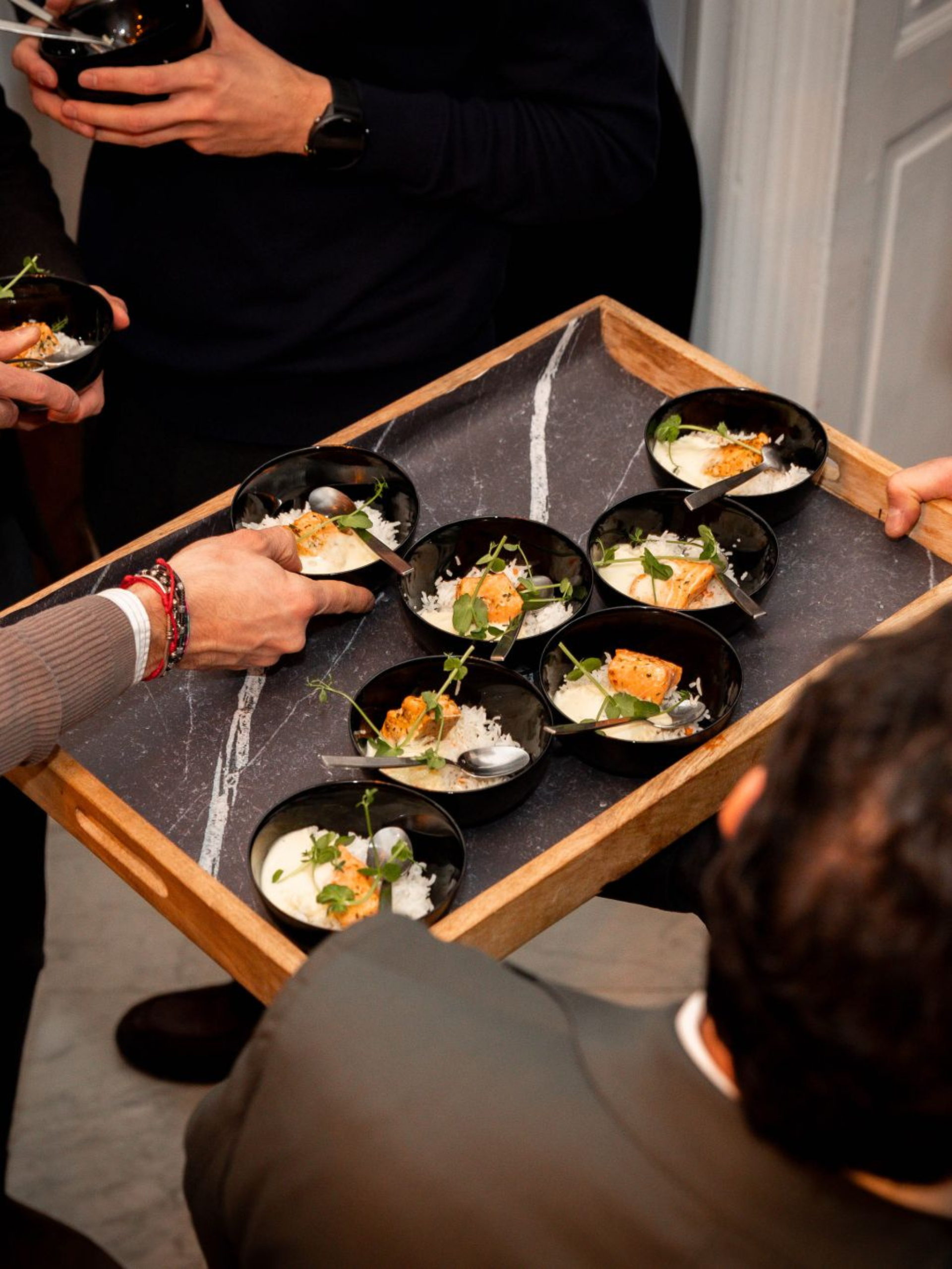 Des invités prennent des bouchées sur un plateau pendant un walking dinner